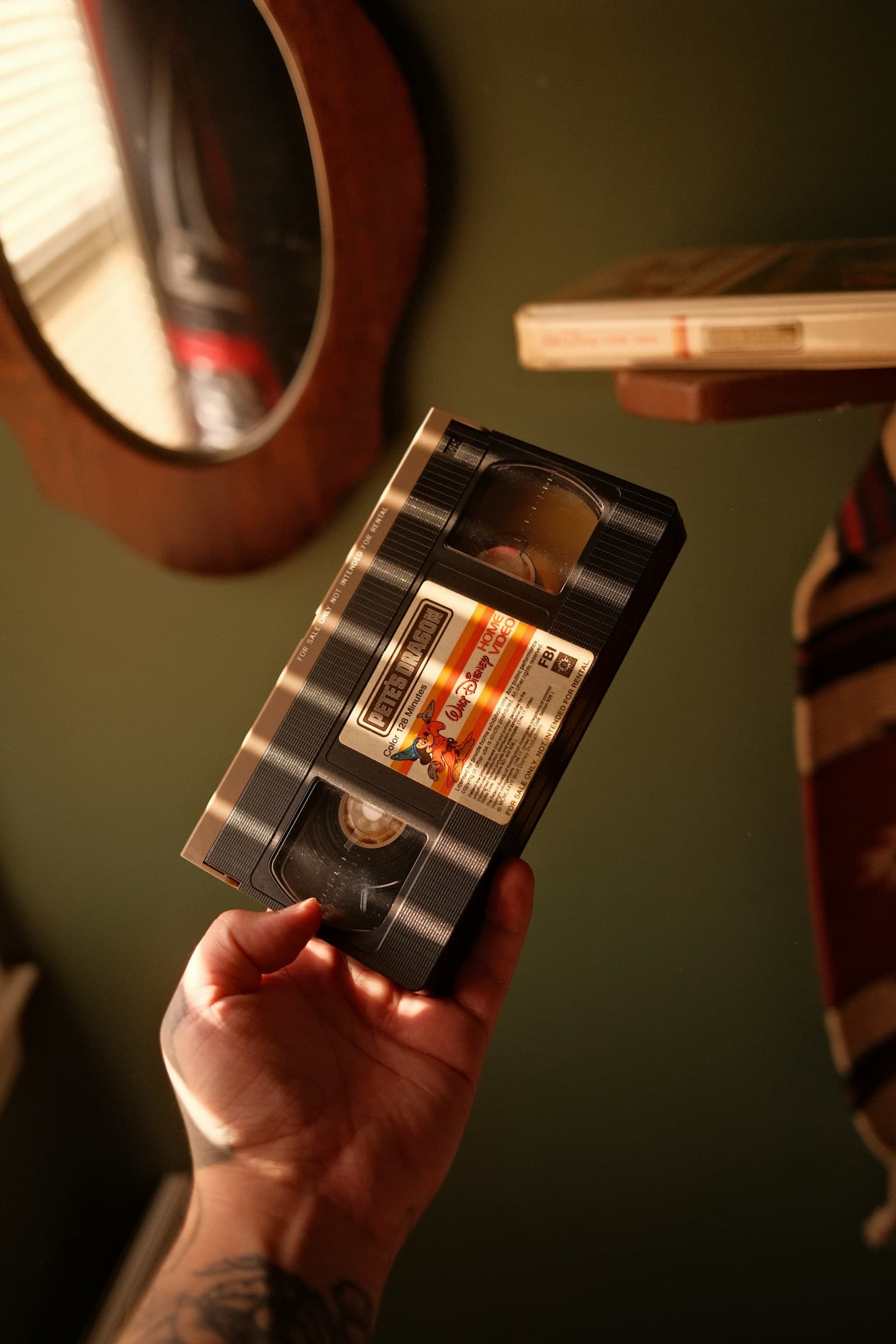A hand holding a retro video tape